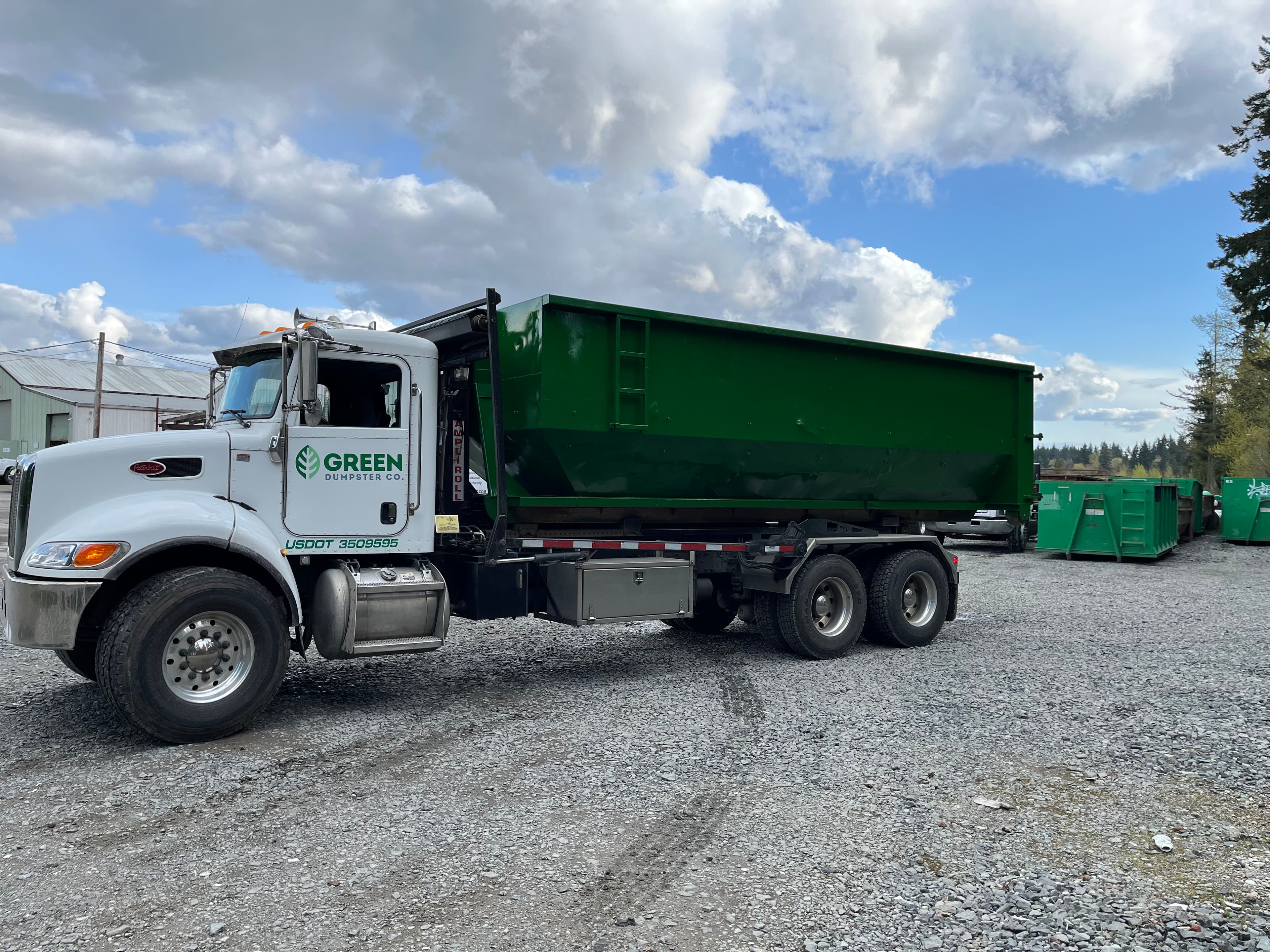 Green Dumpster Co. truck with traditional roll off dumpster